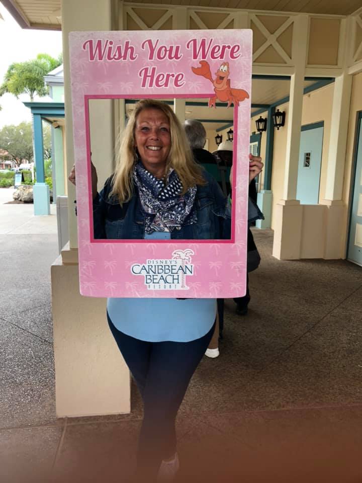 A woman in a photo booth with the word " here " written on it.