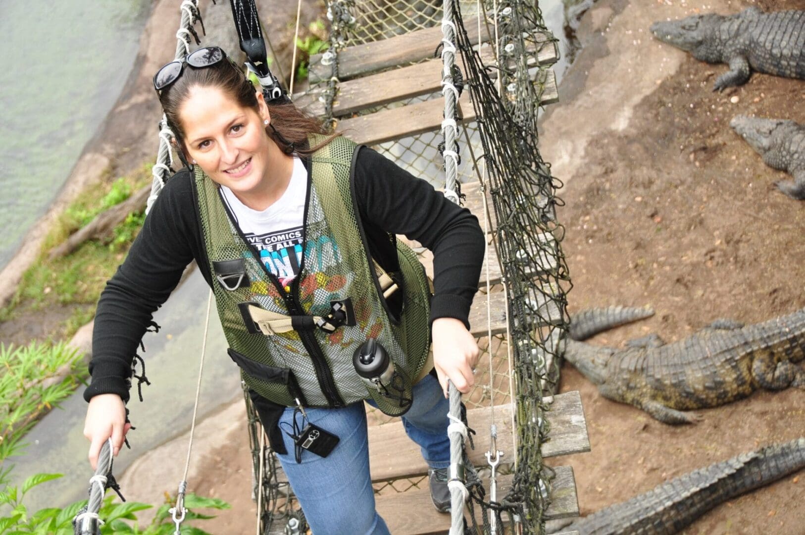 A woman in green vest holding onto rope.