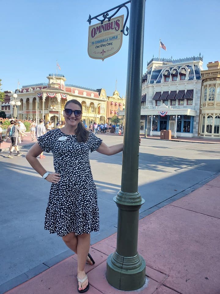 A woman standing next to a street light.