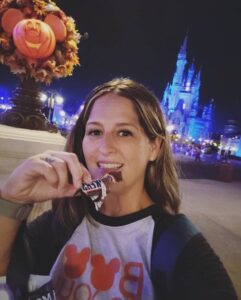 A woman eating chocolate in front of the castle.