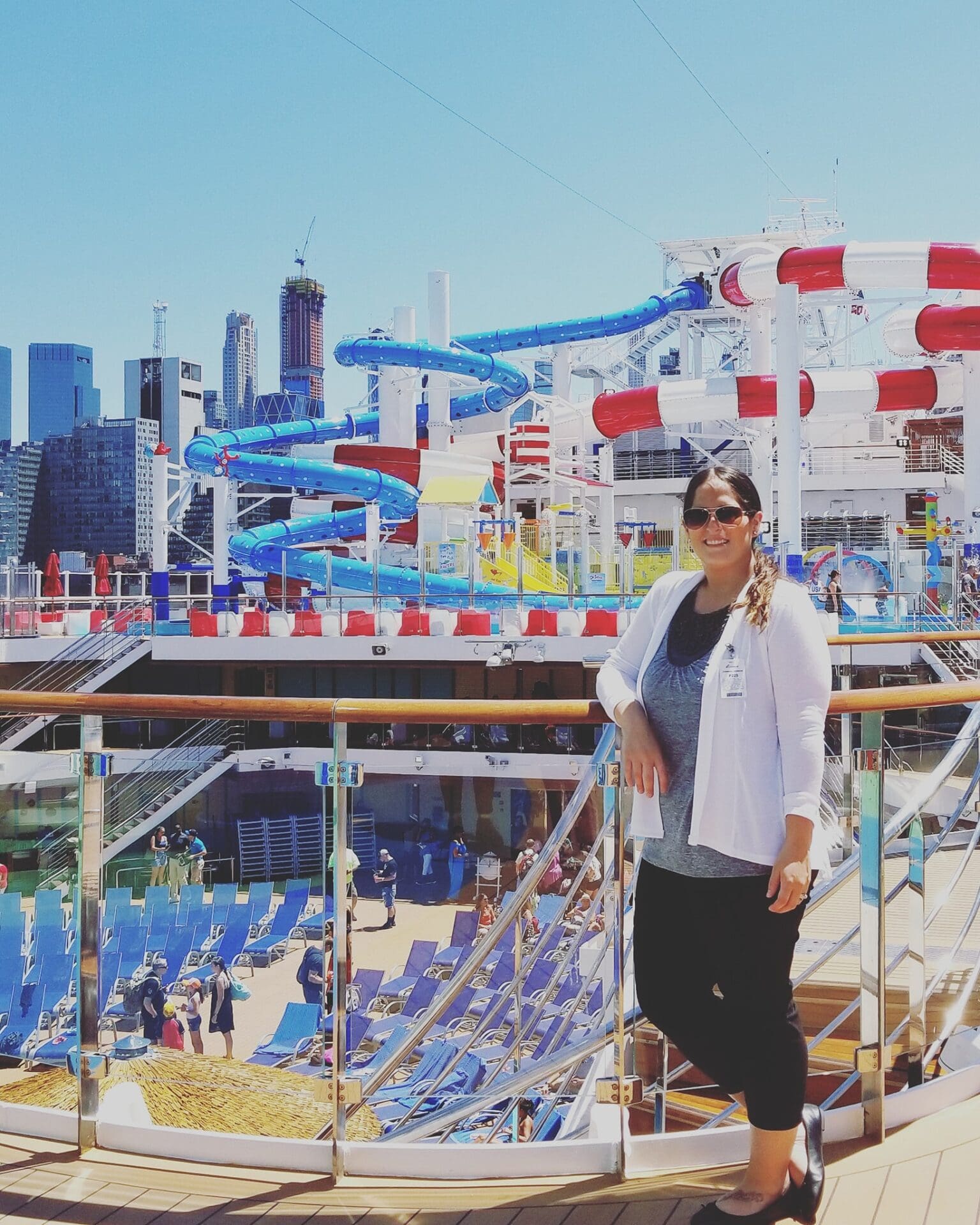 A man standing on the beach with a ferris wheel in the background.