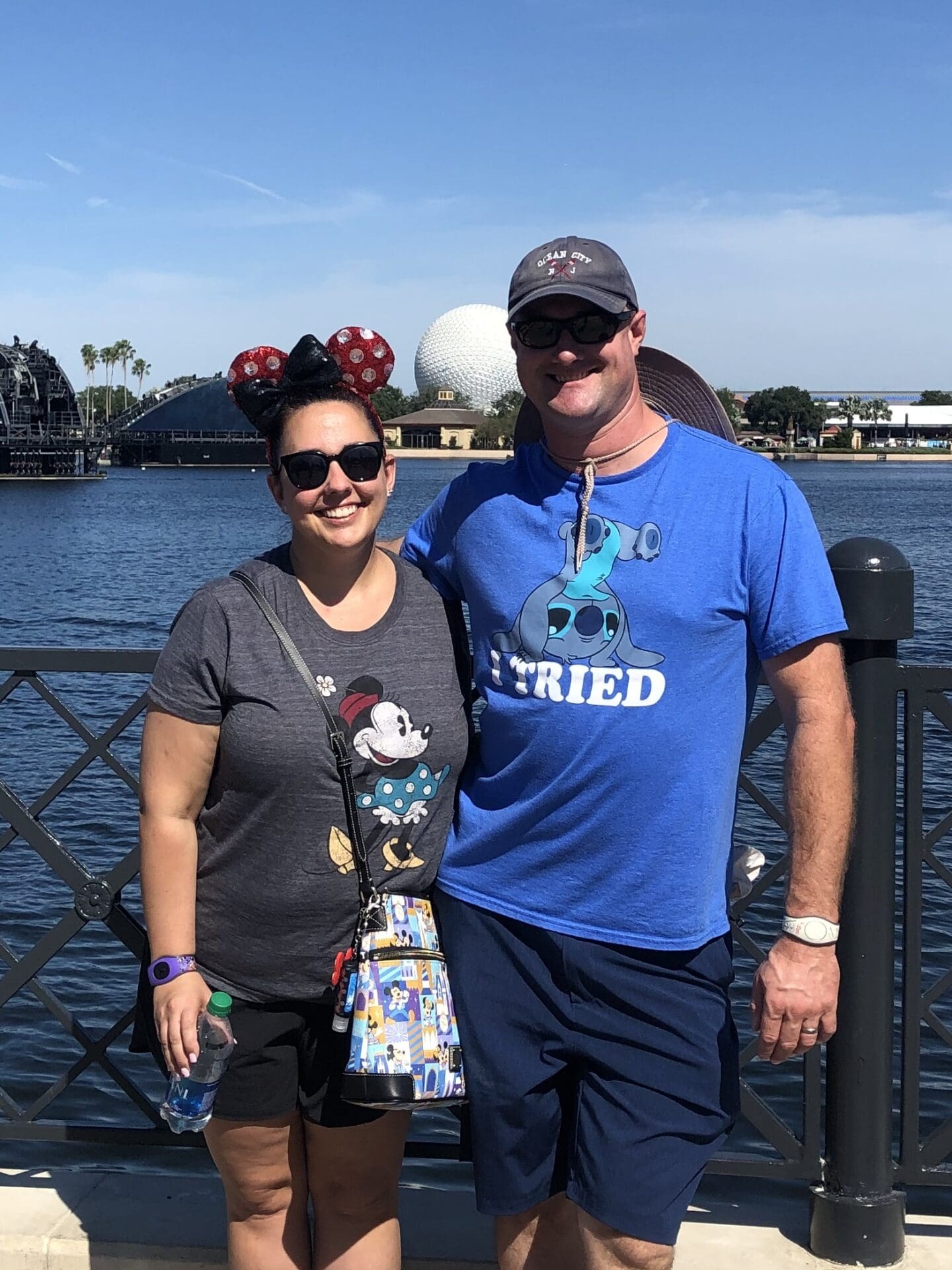 A man and woman standing next to each other near water.