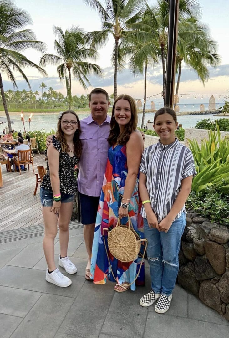 A family posing for a picture in front of the ocean.