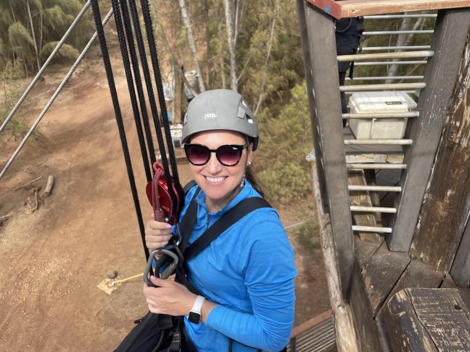 A woman holding onto some ropes while standing on top of a tower.