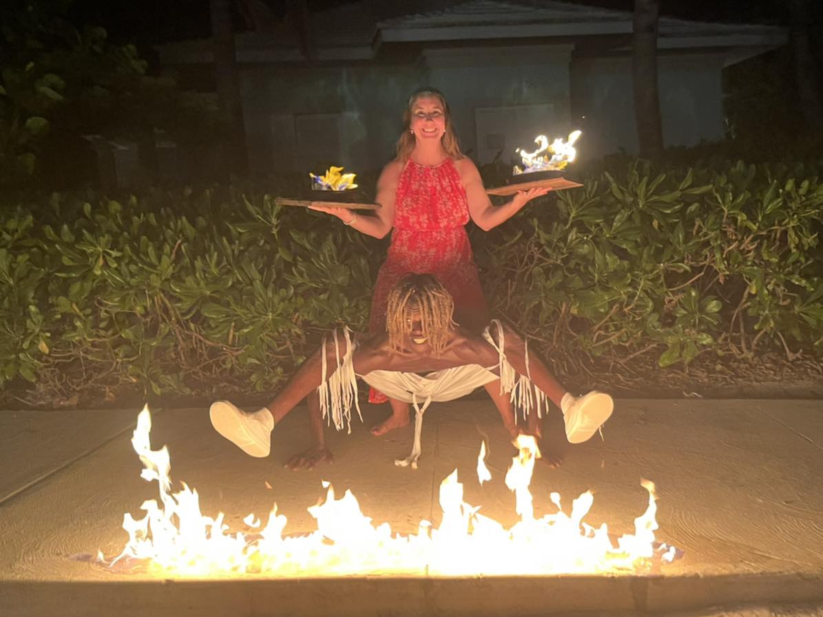 A woman sitting on top of a fire pit holding two bowls.