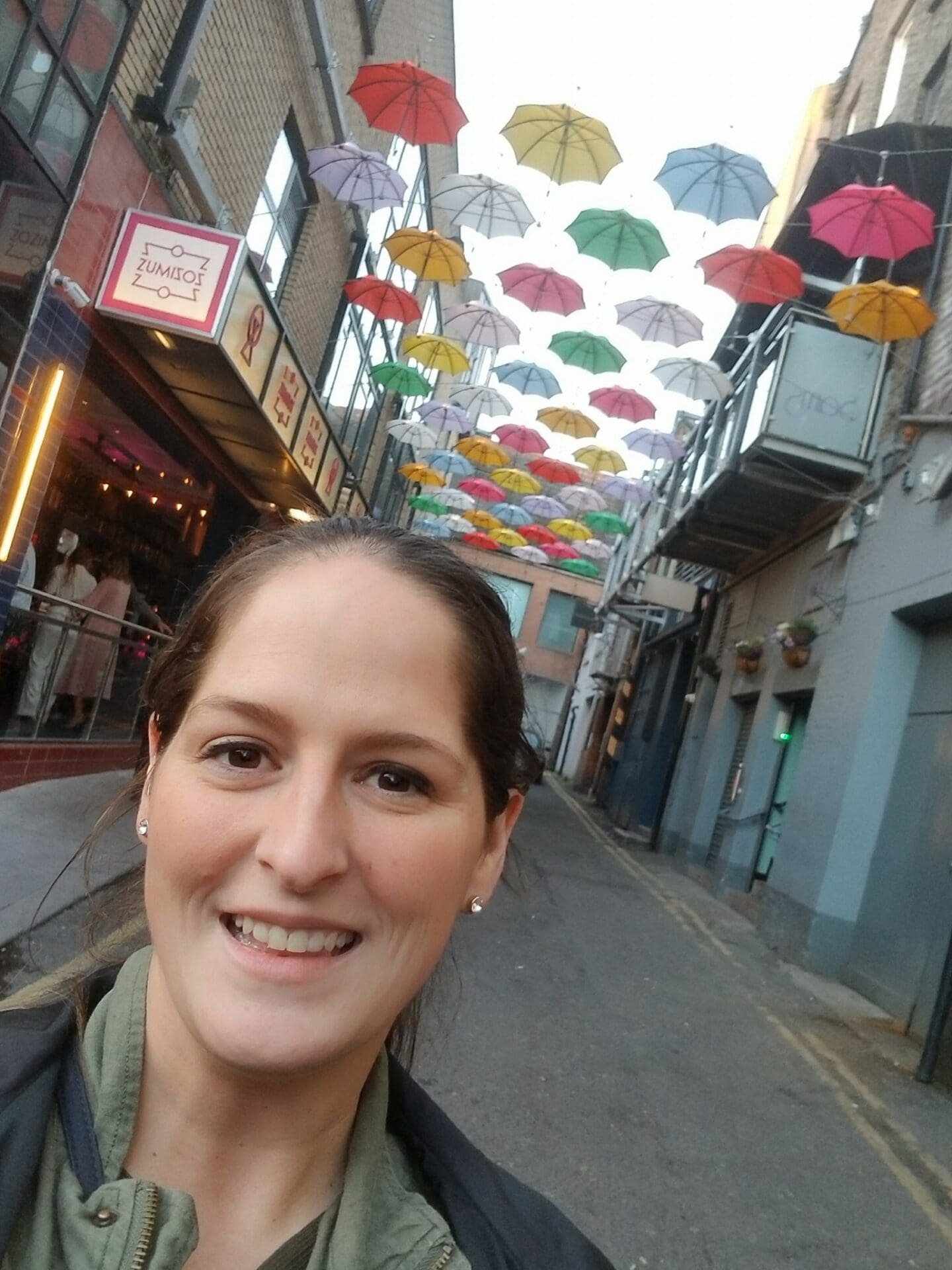 A woman standing in the middle of an alley.