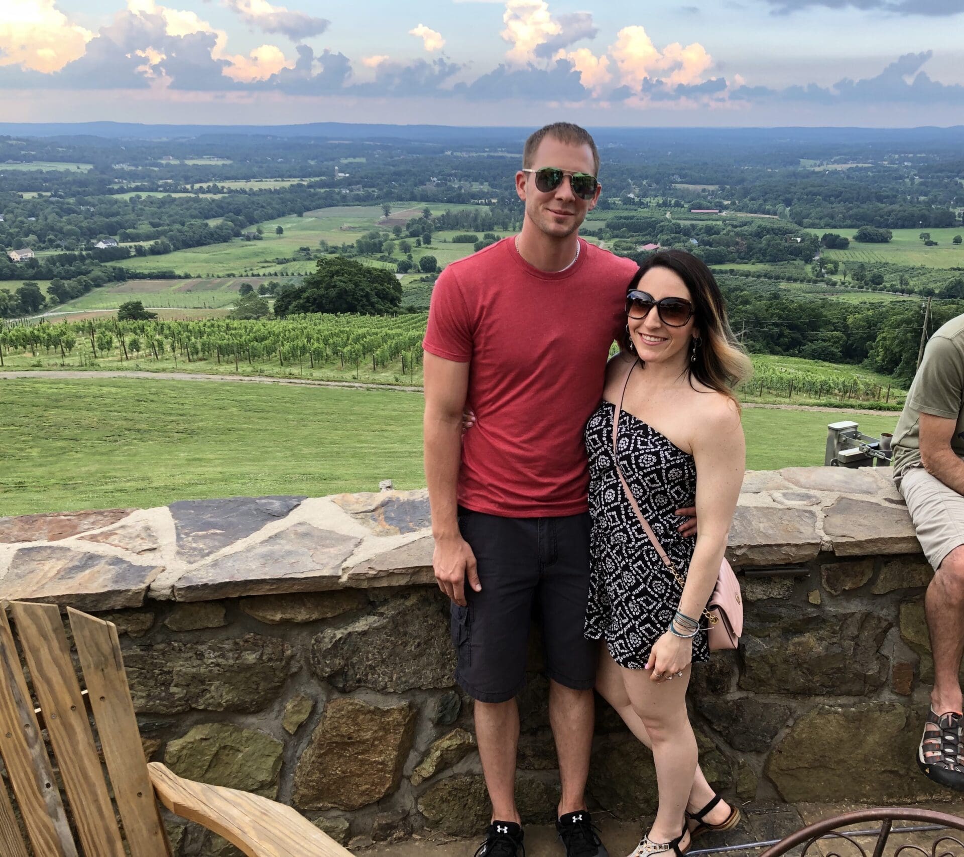 A man and woman standing on top of a hill.