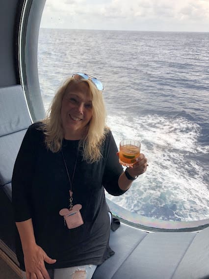 A woman holding a glass of wine on the deck of a boat.