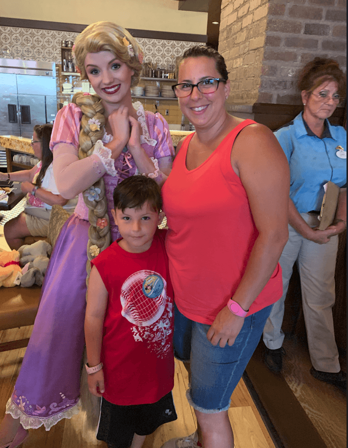 A woman and two children posing with rapunzel.