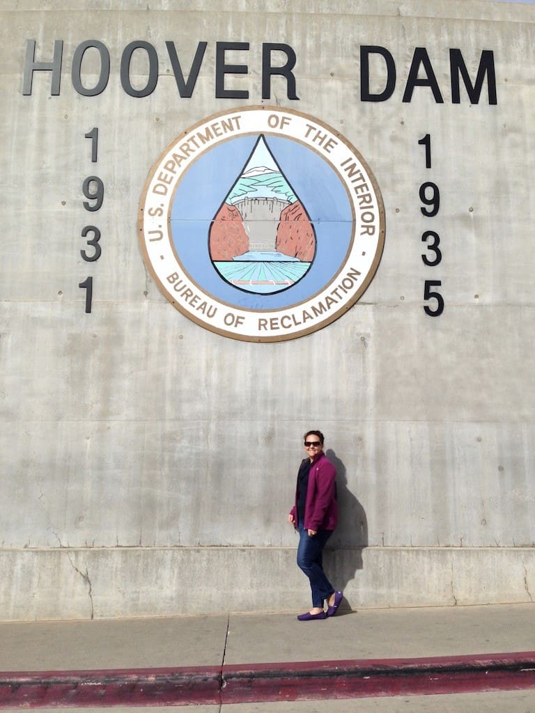 A woman standing in front of the hoover dam.