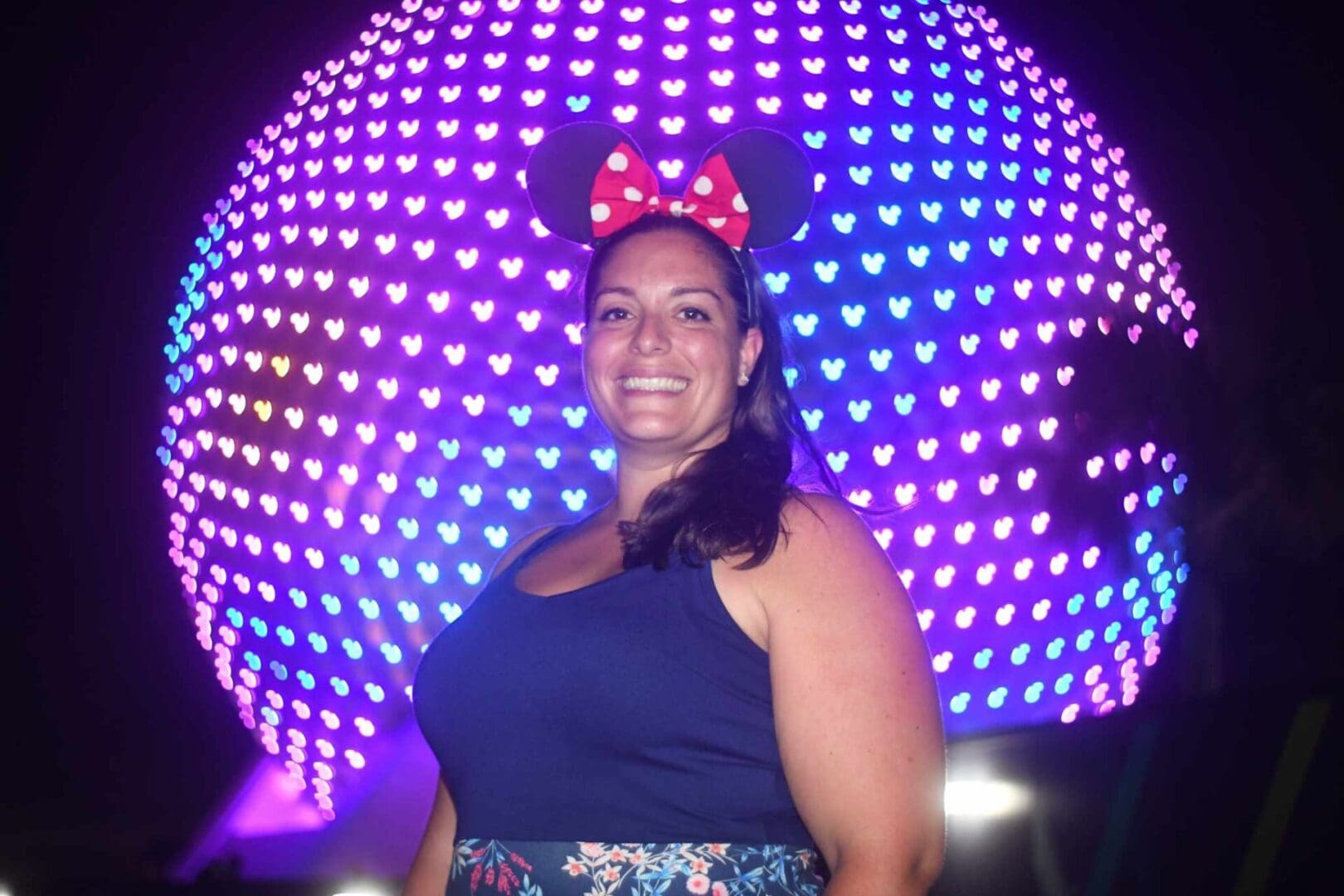 A woman standing in front of a lighted ball.