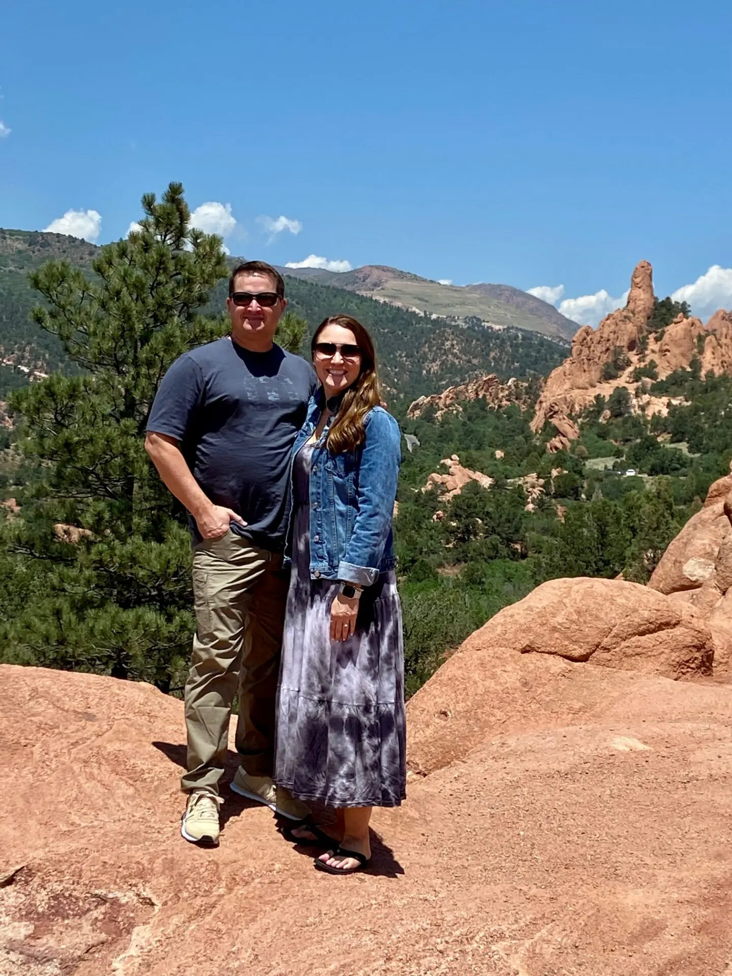 A man and woman standing on top of a mountain.