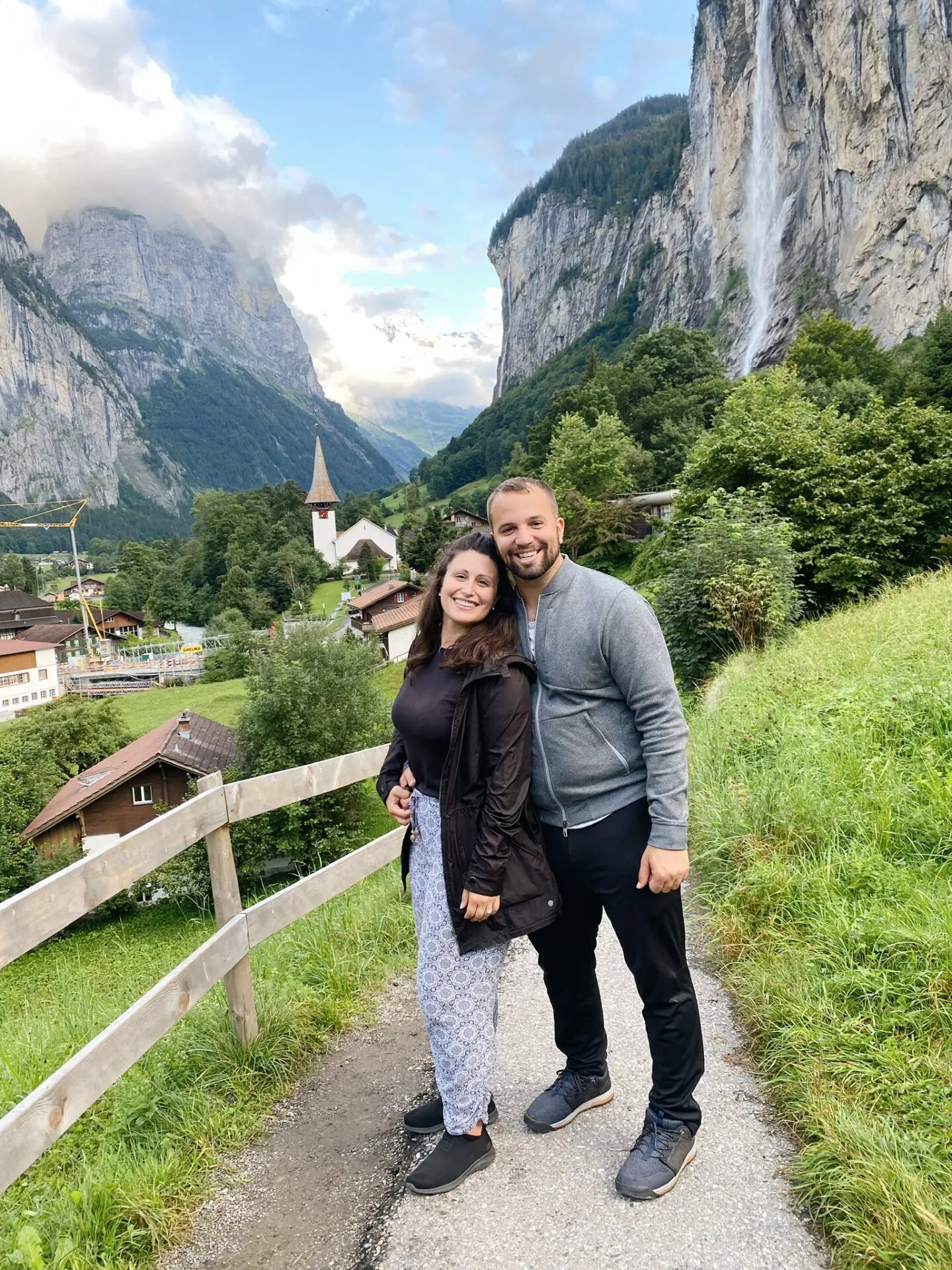 A man and woman standing on the side of a road.