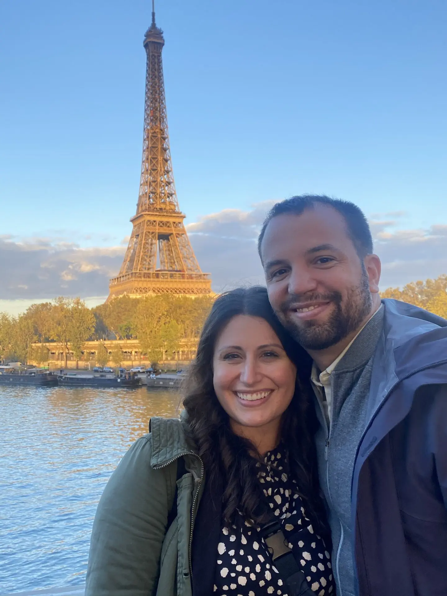 A man and woman standing in front of the eiffel tower.