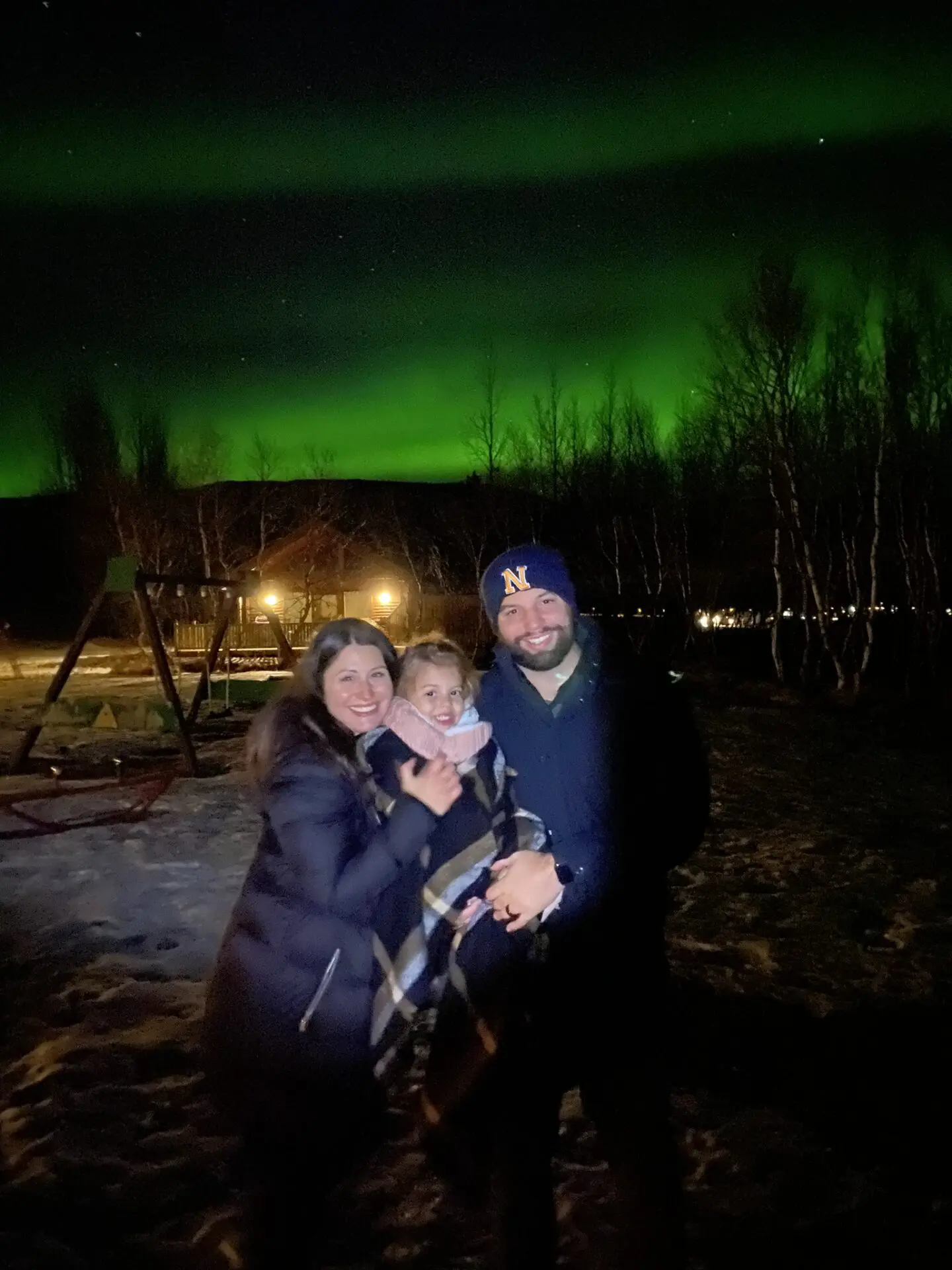 A family standing in front of the aurora borealis.