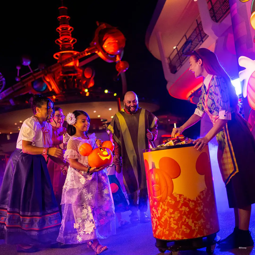 Costumed guests trick-or-treating at Disney park.