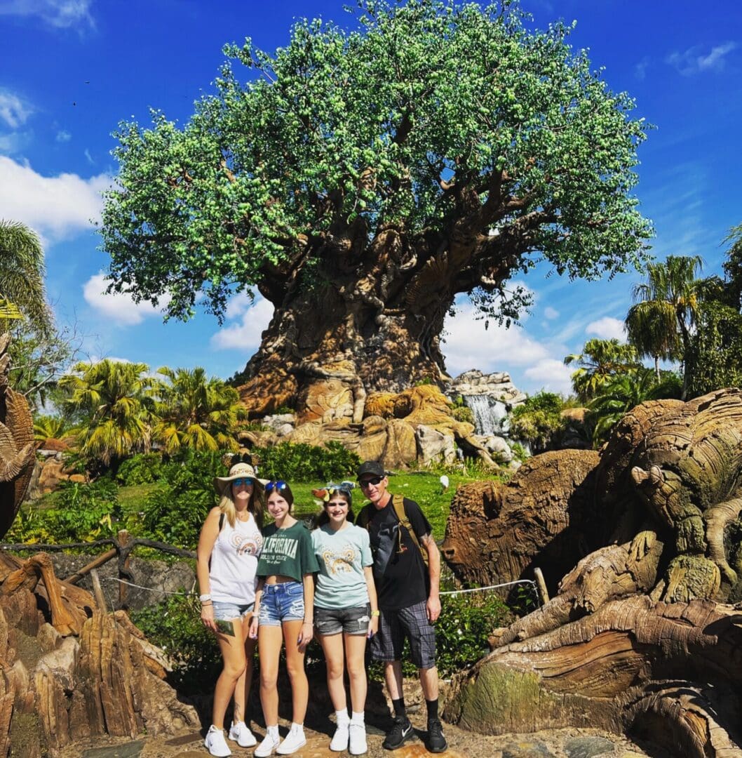 Family posing in front of Tree of Life.