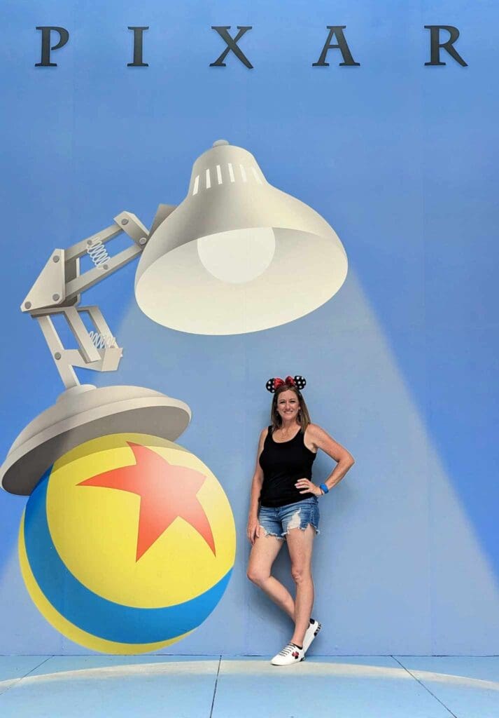 Woman poses with Pixar lamp and ball.