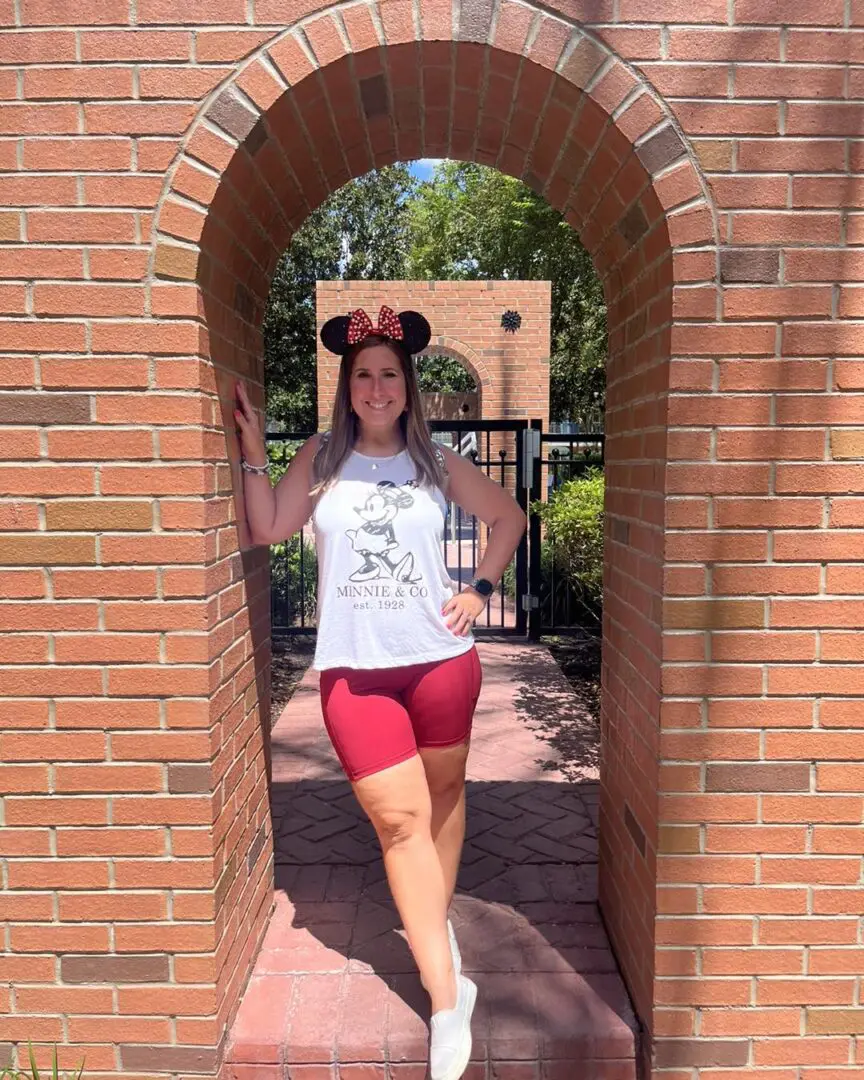 Woman in Minnie Mouse shirt and red shorts.