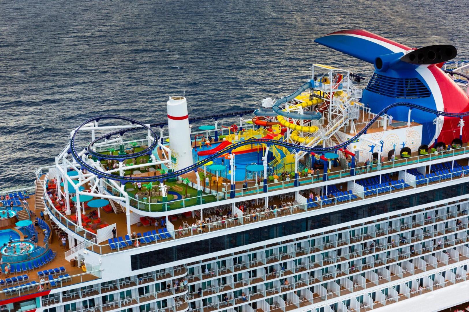 A cruise ship with many colorful slides and a lot of chairs.