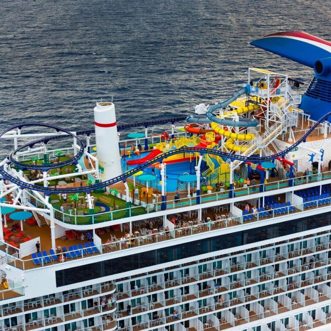 A cruise ship with many colorful slides and a lot of chairs.